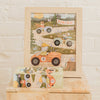 Framed Little Racers 40 Piece Mini puzzle featuring woodland animals racing cars toward a “Finish” line, each with numbered wheels. In front, a magnetic puzzle box with matching artwork sits on a marble surface.