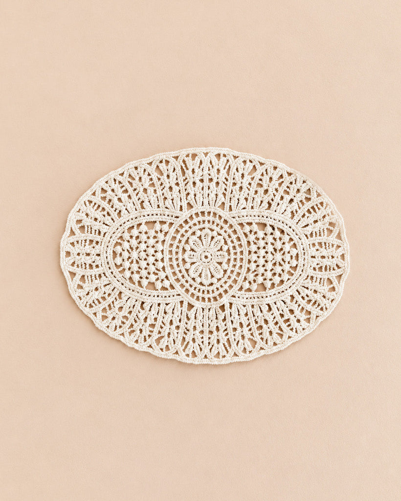 An oval-shaped, intricately woven lace doily with a detailed, symmetrical pattern, placed on a light beige background—perfect for adding an elegant touch to your Maileg Cozy Christmas Corner or enhancing your holiday-themed Maileg dollhouse accessories.