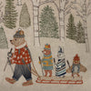 The Coral & Tusk Winter Fun Pillow features embroidered woodland animals—a bear towing a sled with a fox, rabbit, and owl—all in winter clothing with ski poles, set among snowy birch and evergreens for whimsical holiday decor.