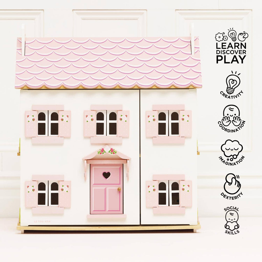 Sophie's Wooden Dolls House, in pastel pink with a heart-shaped door, fosters creativity, coordination, imagination, dexterity, and social skills. FSC-certified for endless play. Icons and text highlight its developmental benefits.