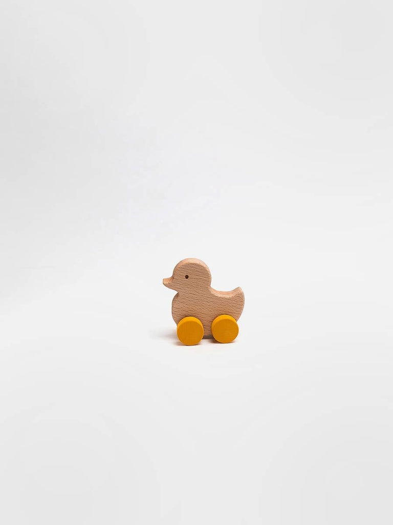 The Sabo Concept Rolling Duck - Yellow, a small heirloom-quality wooden toy with yellow wheels, is centered on a plain white background.