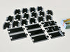 The Large Flexible Toy Race Track - Grand Prix features black plastic track pieces—straight, curved, and finish line sections—arranged in rows on a light surface beside the partially visible product box.