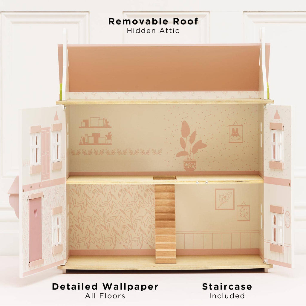 Sophie's Wooden Dolls House is a pastel pink, FSC-certified toy featuring a removable roof that reveals a hidden attic, detailed wallpaper, staircase, illustrated shelves, plants, and windows on pale pink and beige walls.