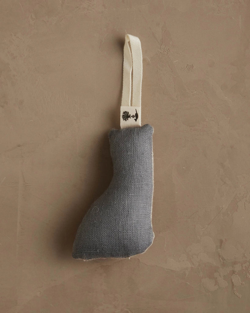 A small gray fabric boot-shaped ornament with a black design hangs from a white loop against a beige background—the Coral & Tusk Fox Tree Trimmer Ornament, perfect as a unique holiday gift.