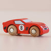 A small red wooden toy race car, the No. 4 GT25 Finley made in England, features classic black details and racing style, with the number 4 on its side, and sits on a light surface.