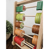 The Fruitful Abacus, an excellent educational tool, features vibrant fruit-shaped counters on its rods. Each row showcases a variety of fruits such as watermelon, citrus slices, and kiwi. A potted plant in the background on a wooden surface enhances the scene, making it perfect for developing counting skills.