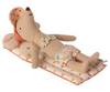 The Maileg Beach Float, Mouse - Multi Dot is lounging on a polka-dotted cushion, resembling an air mattress. This cute mouse is dressed in floral-patterned shorts and a headscarf adorned with red polka dots. It looks completely relaxed, lying on its back with its arms by its sides and feet stretched out.