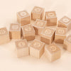 Uncle Goose Number Alphablank Blocks, made of basswood and engraved with numbers 0-9, are displayed on a light beige surface. Each educational block has a decorative border framing the number.