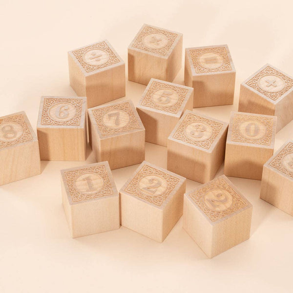 Uncle Goose Number Alphablank Blocks, made of basswood and engraved with numbers 0-9, are displayed on a light beige surface. Each educational block has a decorative border framing the number.