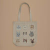 The Cats Tote Bag showcases nine unique cat faces in a 3x3 grid on a beige background, featuring different expressions and fur patterns. It also includes a convenient inside pocket.