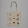 The Cats Tote Bag features illustrated feline faces in unique styles and expressions, arranged in three rows and columns on a gray background, and includes an inside pocket for added convenience.