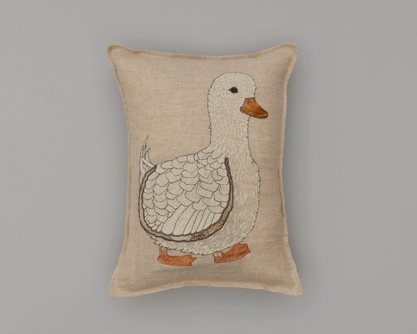 Rectangular decorative pillow with an embroidered Coral & Tusk Mama Duck Pocket Pillow design on a beige background. The duck features intricate stitching details on its body and orange feet and beak.