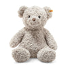 A soft and fluffy 19-inch Honey Teddy Bear from Steiff sits upright, showcasing its curly texture with light brown fur. It features round ears and a small brown nose, with a signature yellow tag on its left ear. The plush bear is set against a plain white background.