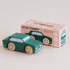 A green classic wooden car sits beside its box, which features an illustration of the car and the text “No. 3 GT20 Tommy | Made in England.” The toy has wooden wheels and simple painted details, capturing the charm of a nostalgic toy.