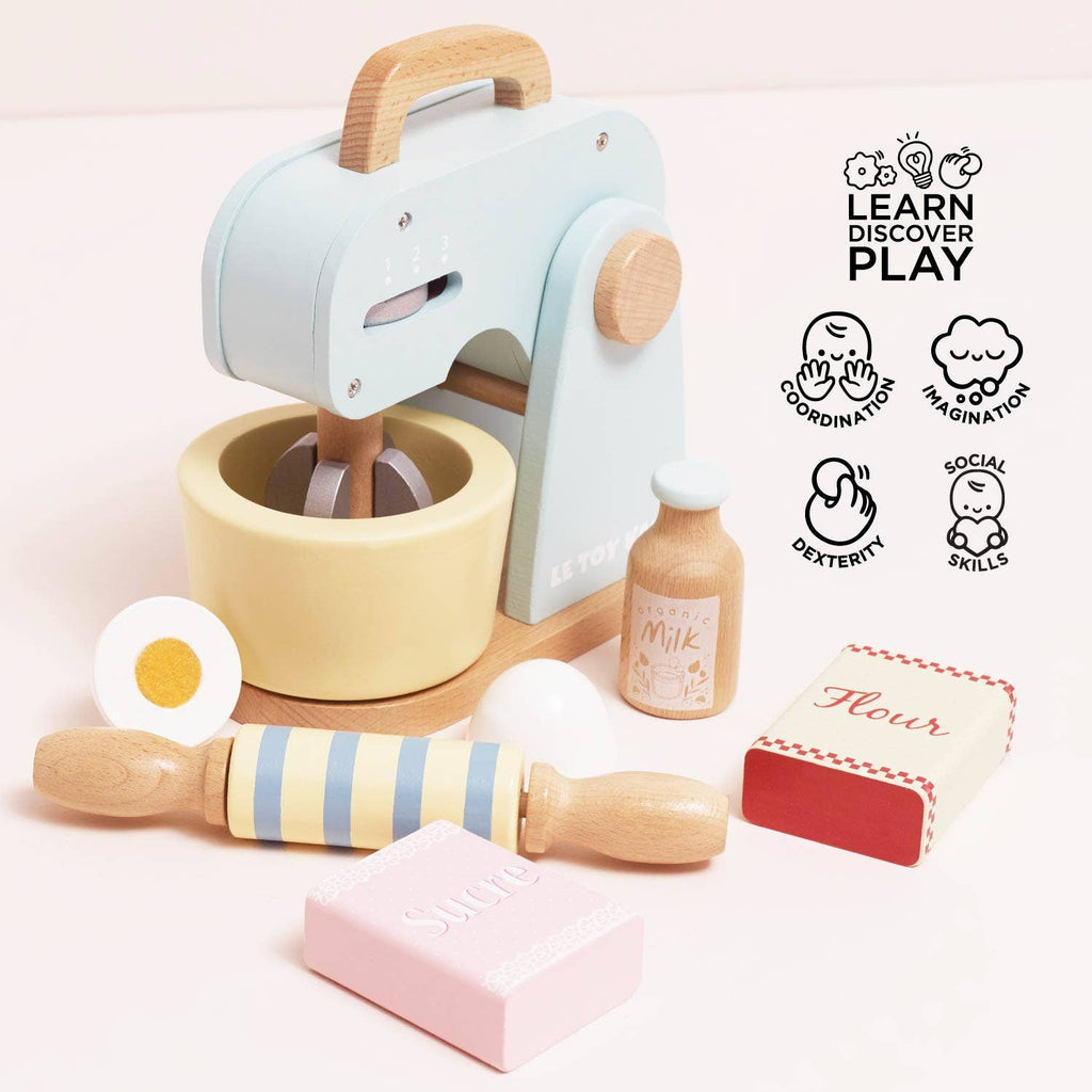 The Bakers Mixer Set & Accessories features pastel wooden pieces—a bowl, rolling pin, milk bottle, egg, and labeled sugar and flour boxes—perfect for pretend play that encourages learning, coordination, imagination, social skills, and dexterity.