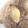 Close-up of the Light at Night Caspar Teddy Bear showing its beige plush fabric and open back zipper, revealing a bright yellow night light inside. The soft, fuzzy exterior contrasts with the smooth glowing surface similar to a USB charger.