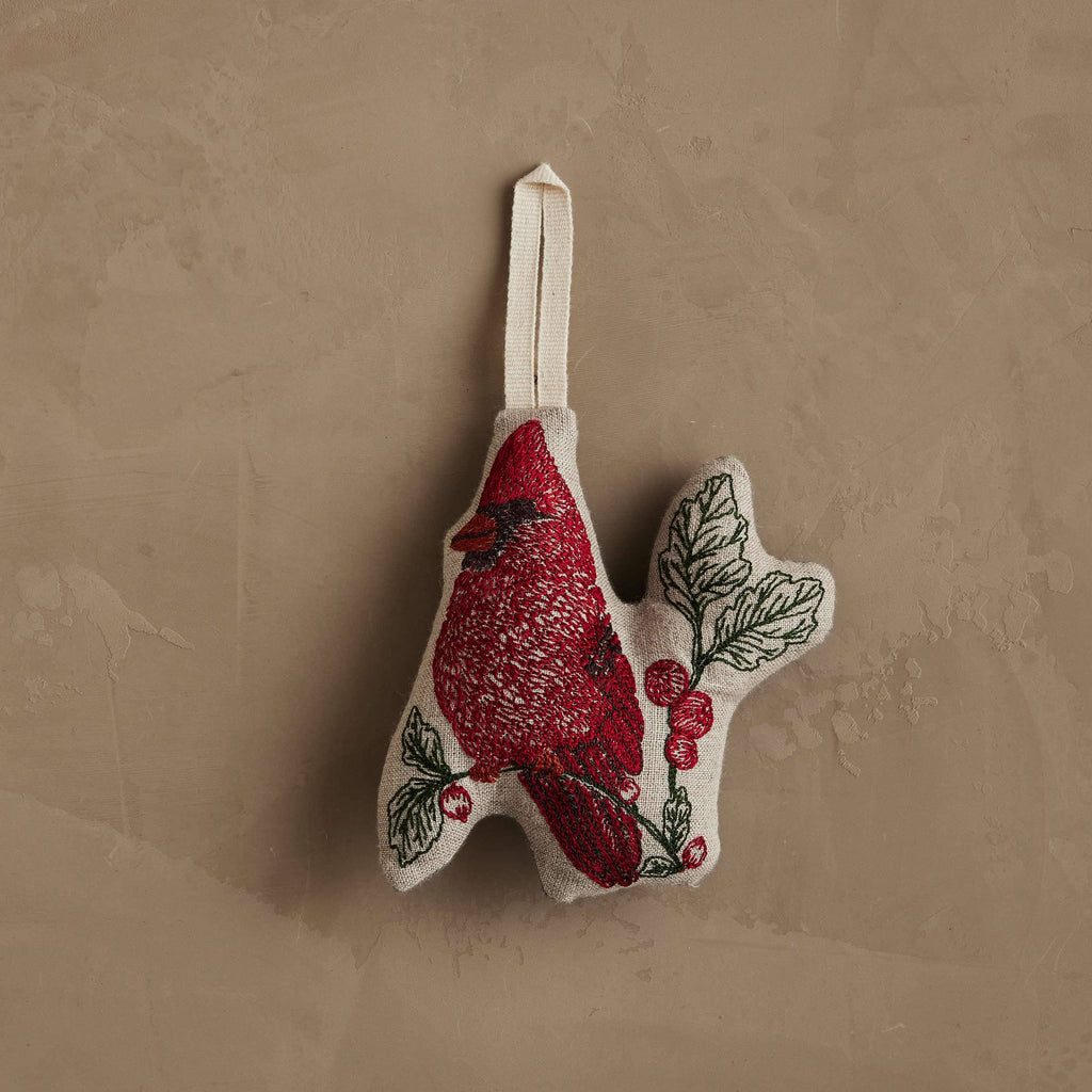 Coral & Tusk Red Cardinal Ornament featuring an embroidered bird perched on a branch with red berries on natural linen, finished with a cream-colored hanging loop.