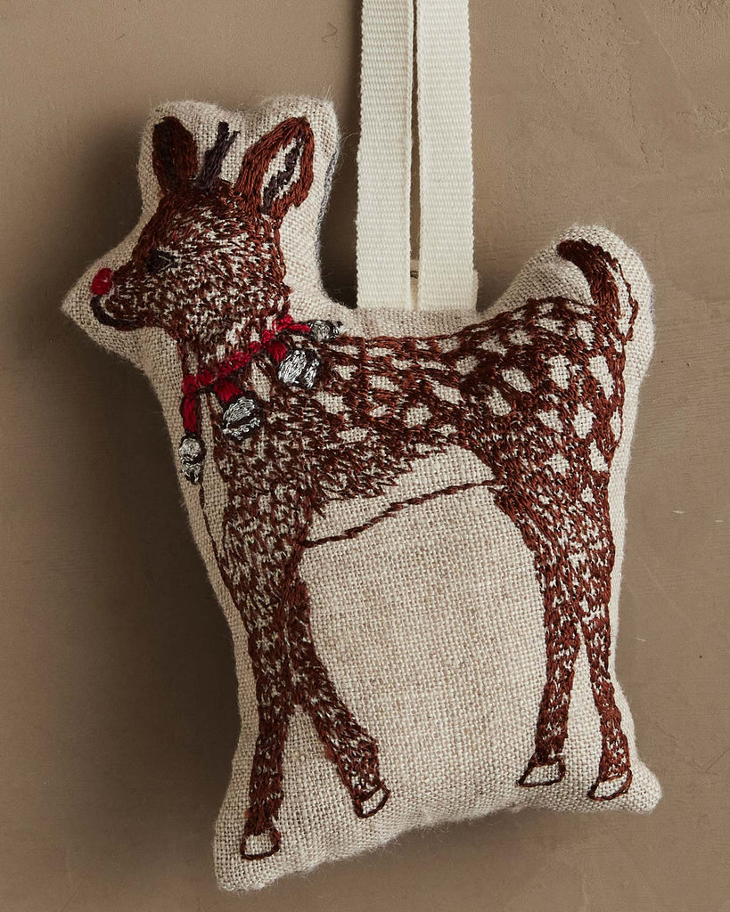 The Coral & Tusk Rudolph Ornament is a small, stuffed reindeer with embroidered brown spots, red nose, and a red collar with silver bells—an adorable addition to your Christmas tree or festive décor.