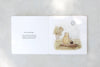 Open Winnie-the-Pooh: Finding Feelings board book to read about Pooh and Piglet exploring emotions, with an illustration of them on a log watching a balloon float by among the trees.