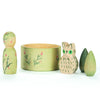 Five wooden toys from the Hello Winter Set (Grapat X Ostheimer Limited Edition), featuring green and pink details, are arranged in a row on a white background.