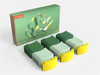 The WaytoPlay: Arches - Builder Set is shown with its box behind three rows of curved plastic track pieces in varying shades of green and yellow, neatly arranged on a white surface—this creative construction toy encourages imaginative play and offers endless building possibilities for children.