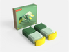 A box labeled “WaytoPlay: Arches - Creator Set” sits next to two rows of green and yellow curved toy pieces, arranged neatly on a white surface. This creative construction set inspires imaginative play and endless building possibilities.