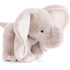 The Bukowski - August Elephant is a huggable plush toy featuring soft, light gray fur, large floppy ears, a curved trunk, and black button eyes. Standing on all four legs against a white background, it’s perfect for bedtime snuggles.