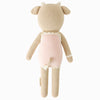 Cuddle + Kind Ava the Cow - Powder Pink is a hand-knit Peruvian doll made from 100% cotton yarn, featuring a cow with beige limbs, horns, and ears, dressed in light pink with a small tail showing from the back.