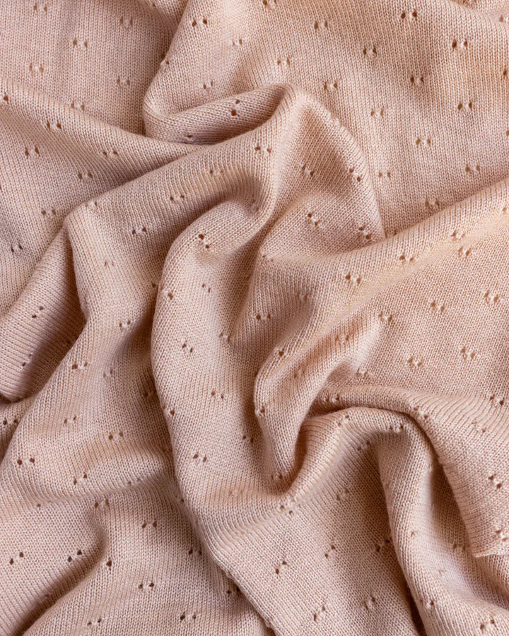 Close-up of a Handmade Merino Wool Bibi Blanket - Apricot with a textured, dotted pattern, gently folded and textured to show dimension and detail.