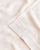 Close-up of a cream textured Handmade Merino Wool Bibi Blanket with small, evenly spaced embroidered dots and a neatly stitched hem. The material appears soft and lightweight, suitable for sensitive skin.