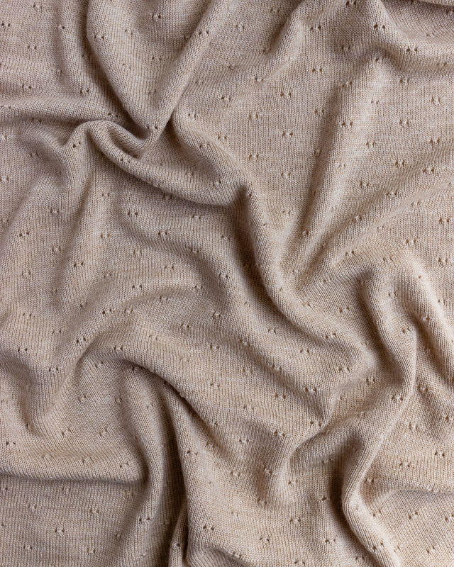 Close-up of a Handmade Merino Wool Bibi Blanket - Sand with small, regular bumps and gentle, undulating folds.