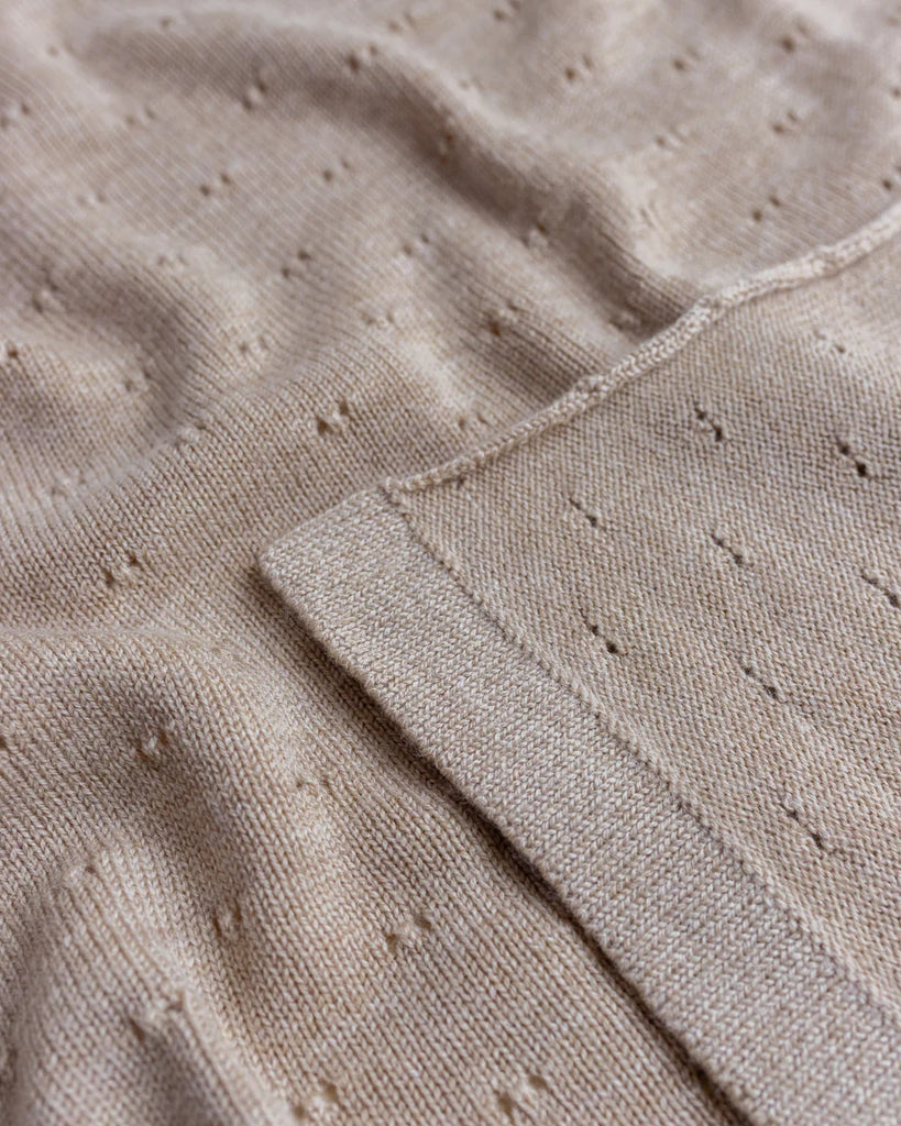 Close-up of a Sand Handmade Merino Wool Bibi Blanket featuring a detailed stitch pattern and a neatly sewn hem, highlighting the fabric’s texture and craftsmanship.