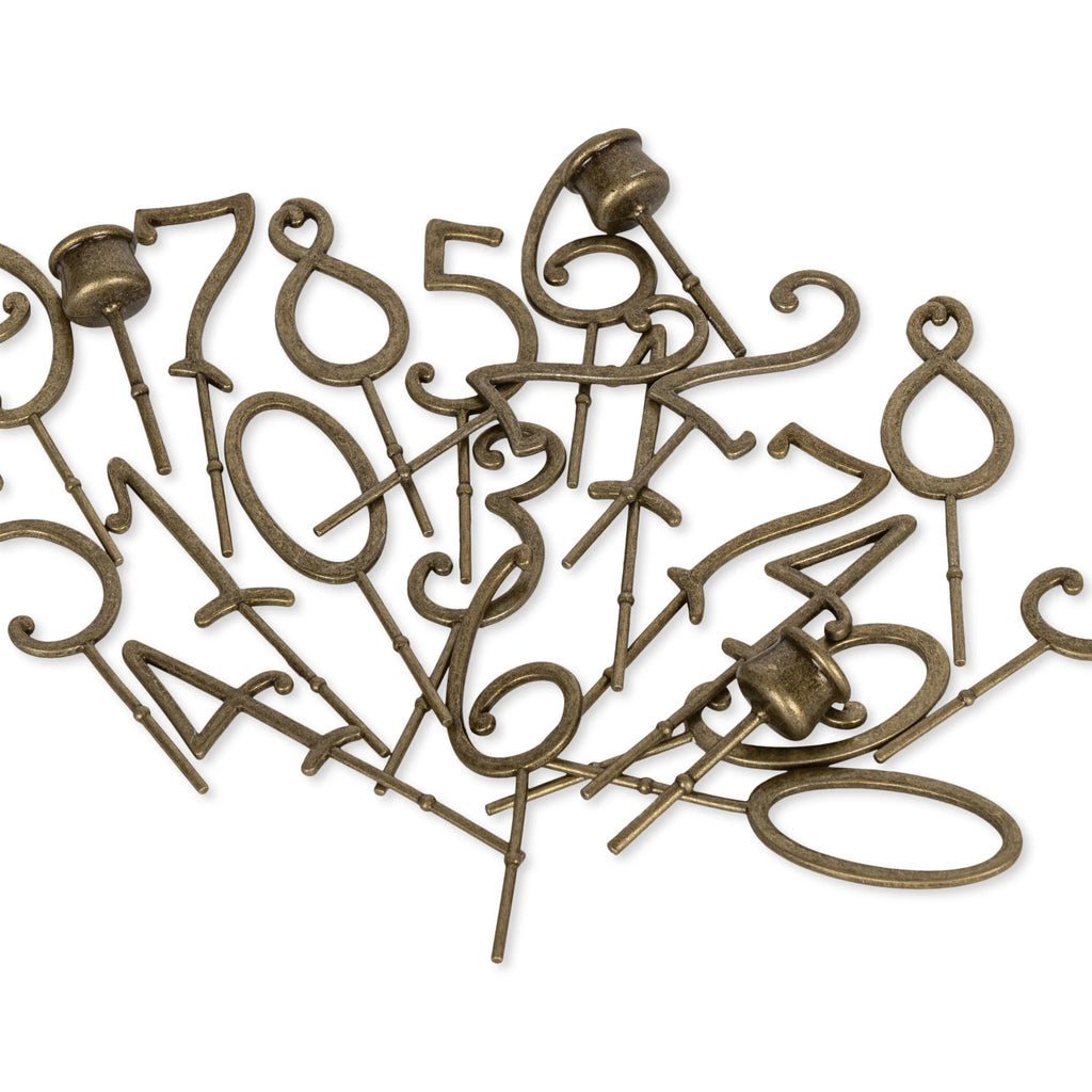 A scattered pile of bronze-colored interchangeable numbers (0–9) with pins, displayed on a white background—ideal for customizing your Magical Forest Birthday Train With Beeswax Candles or any birthday train set.