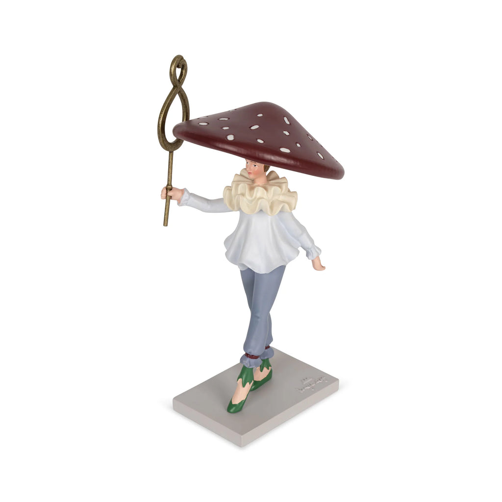 The Magical Forest Birthday Train With Beeswax Candles includes a whimsical figurine in a red, white-spotted mushroom cap, blue pants, and ruffled shirt, holding a staff, on a base designed to display interchangeable birthday numbers.