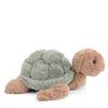 The Bukowski Baby Sandy Sea Turtle is a plush toy with a soft green shell and light brown head, legs, and tail, shown against a white background.