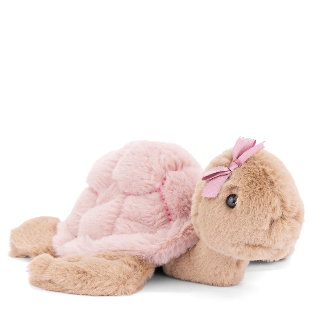 The Bukowski Baby Sandy Sea Turtle - Pink is a plush toy with a light brown body, soft pink shell, and a pink bow on its head. This adorable sea turtle features a cute expression and lies down, making it perfect for cuddling.