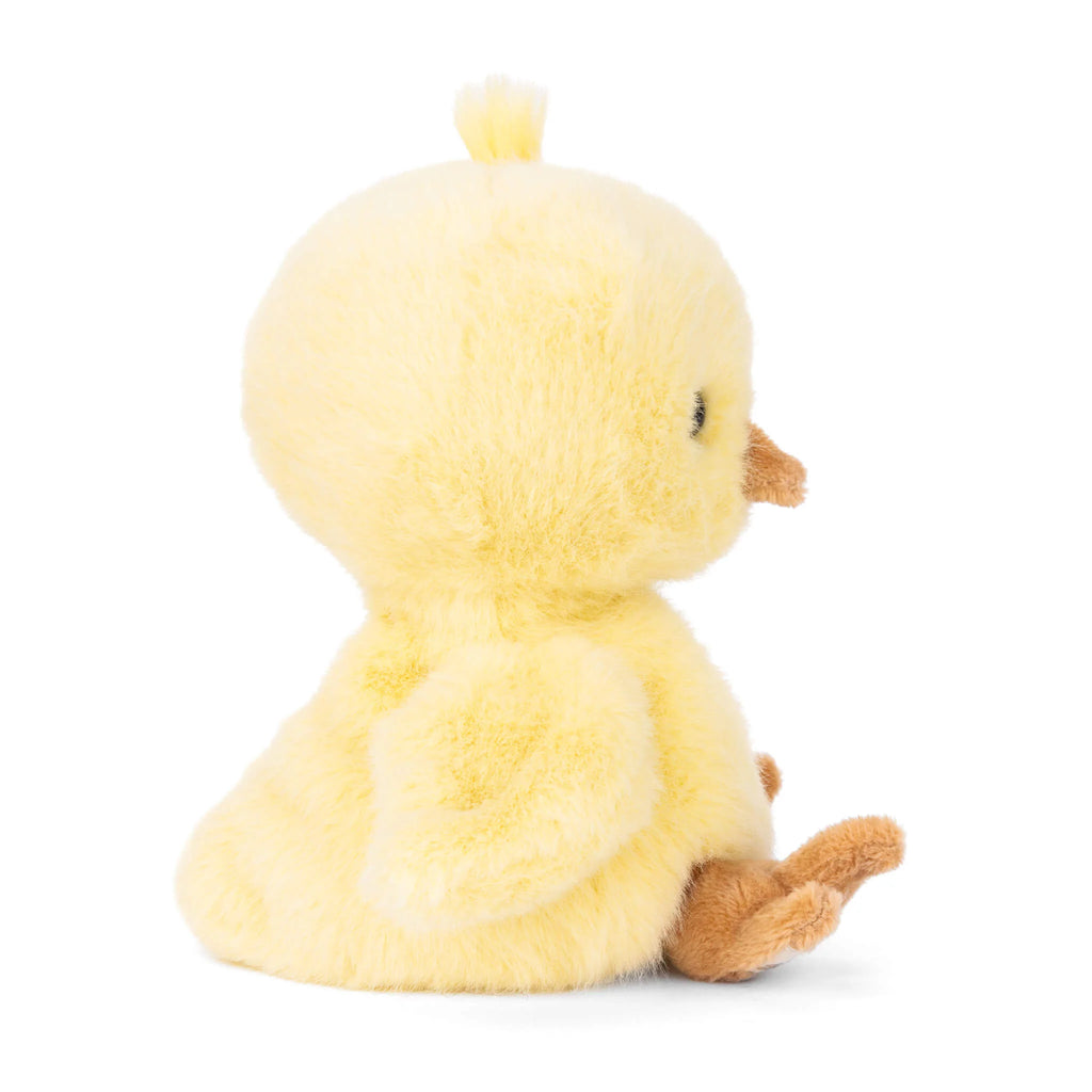 The Bukowski - Baby Chicky plush toy is a soft, yellow chick that sits upright facing to the right, displaying its side profile. It features a small brown beak and feet, as well as tiny wings on its sides. The background is plain white.
