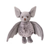 The Bukowski - Baltazar Bat is a plush soft toy featuring large ears, round eyes, a furry body, and outstretched wings, standing upright against a white background.