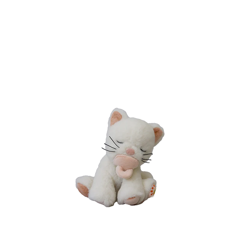 The Olli Ella Binky Kitten Kiki - White is a soft plush with closed eyes, pink ears, nose, and paw pads, sitting upright and holding a light pink heart—an adorable cuddle toy for any cat lover.