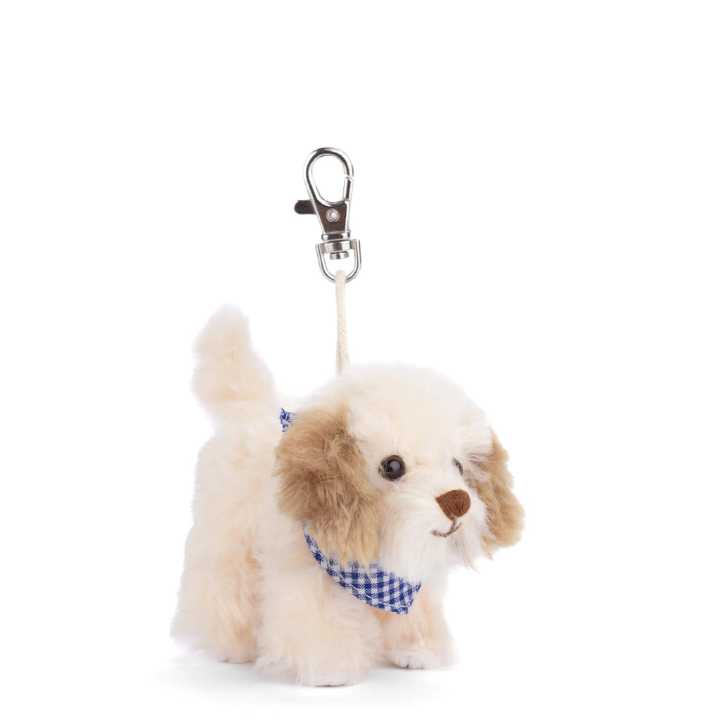 Introducing the Bukowski - Buddylina Dog Bag Charm: a plush puppy keychain featuring soft cream and brown fur, adorned with a blue and white checkered bandana, and attached to a silver clip—perfect as an adorable handbag accessory or bag charm.