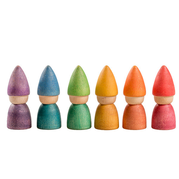 Six Grapat Rainbow Tomten figures arranged in a line, each featuring a distinct color: purple, blue, green, yellow, orange, and red, with cone-shaped tops and rounded bases