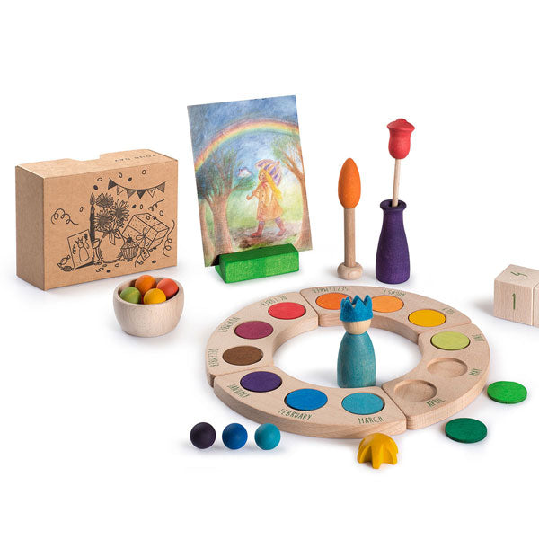 A children's art-themed playset featuring a color wheel, paintbrushes, a mini easel with a painting of a rainbow, colored balls, and Grapat Your Day.