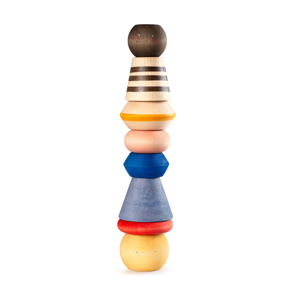 The Grapat Serendipity Stacking Toy features eight handcrafted wooden pieces in vibrant colors, including a sphere, cone, and polygons, creating a totem-like vertical stack that balances artfully. Ships in approximately one week.