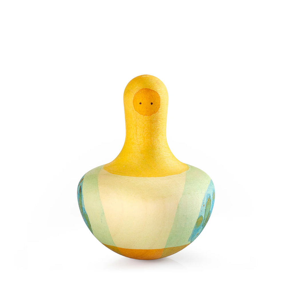 The Grapat Flowing Yellow Bird Rocking Toy features a wooden bird figure with an elongated neck, colorful wings, and a round base. It is painted in pastel shades of yellow, green, and blue with simple dot eyes on a minimalist white background. Ships in approximately one week.