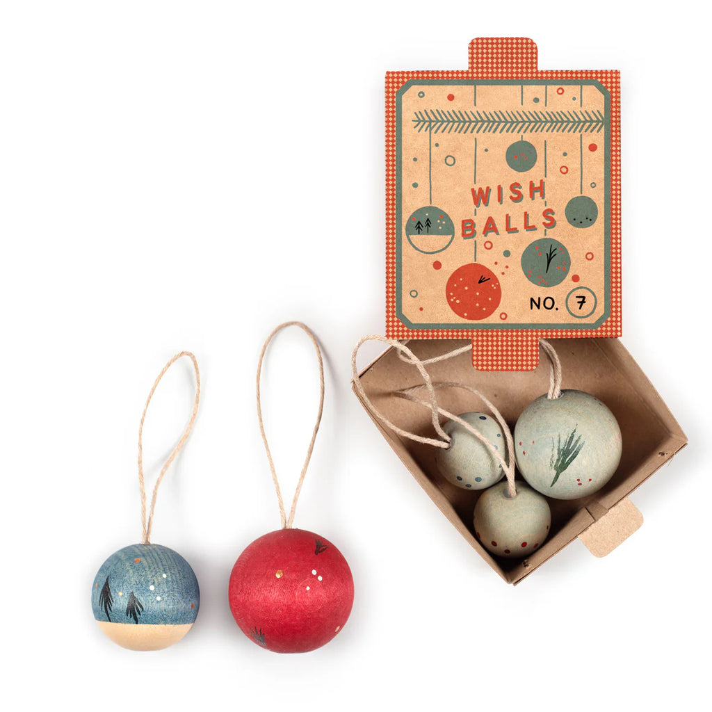 The Grapat Ornament Set - Wish Balls features four round, hand-painted ornaments in blue, red, and beige with festive designs. Displayed near an open box with a "Wish Balls No. 7" lid, two ornaments are shown outside the box.
