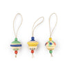Add festive charm to your tree with the Grapat Ornament Set - No 8 - Kind Folks: three hand-painted wooden ornaments, each with a string for hanging and unique hats in green, yellow, and colorful dots.
