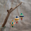 Three small, hand-painted figures from the Grapat Ornament Set - No 8 - Kind Folks hang by strings, each with colorful patterns and beads, perfect for festive decor on a branch or tree.