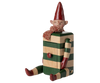 PRE-ORDER: Maileg Elf with Drawer - Green features a collectible wooden elf figurine with a striped green and beige body, red mittens, boots, scarf, and hat, pointed ears, a smiling face, and seated pose. Estimated arrival: mid August.