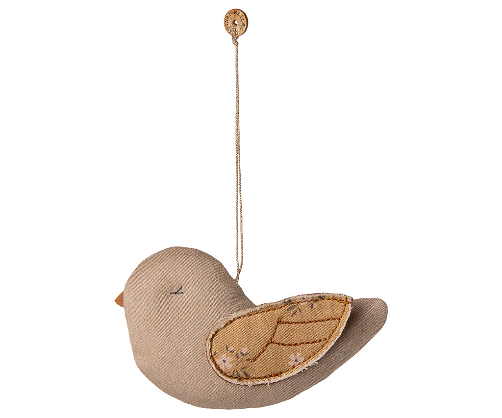 The Maileg Fabric Ornament, Bird - Mable - Latte features a soft fabric bird with stitched details, hanging from a button by a thin string—ideal for adding charm to your Maileg collection or decorating your Christmas tree.