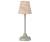 The Maileg Fully Furnished SuitCasa Set includes a charming table lamp with a pale green base and cream lampshade with pink flowers—perfect for brightening any mouse house or enhancing your Maileg SuitCasa display.